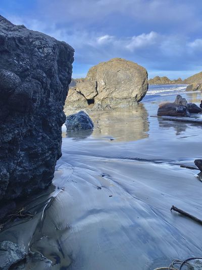 Rock formation in sea against sky