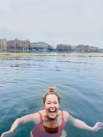 Smiling woman full of joy cold water swimming in denmark