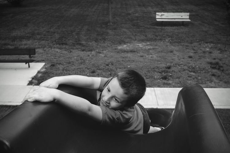 High angle view of boy enjoying slide at playground