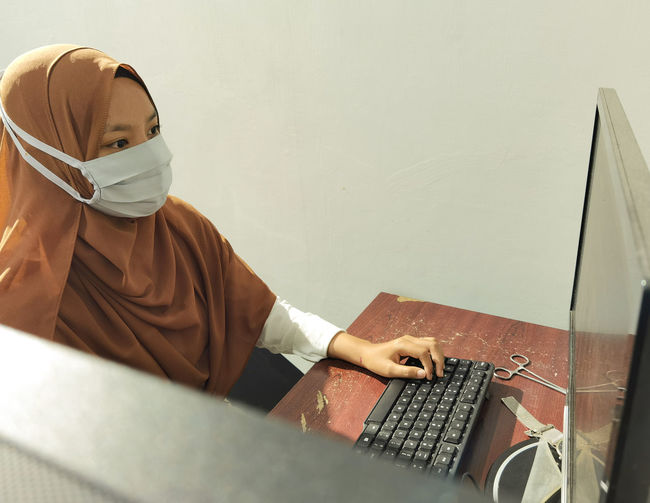 A female worker wearing a face mask due to the covid19 pandemic and still needed to go to the office