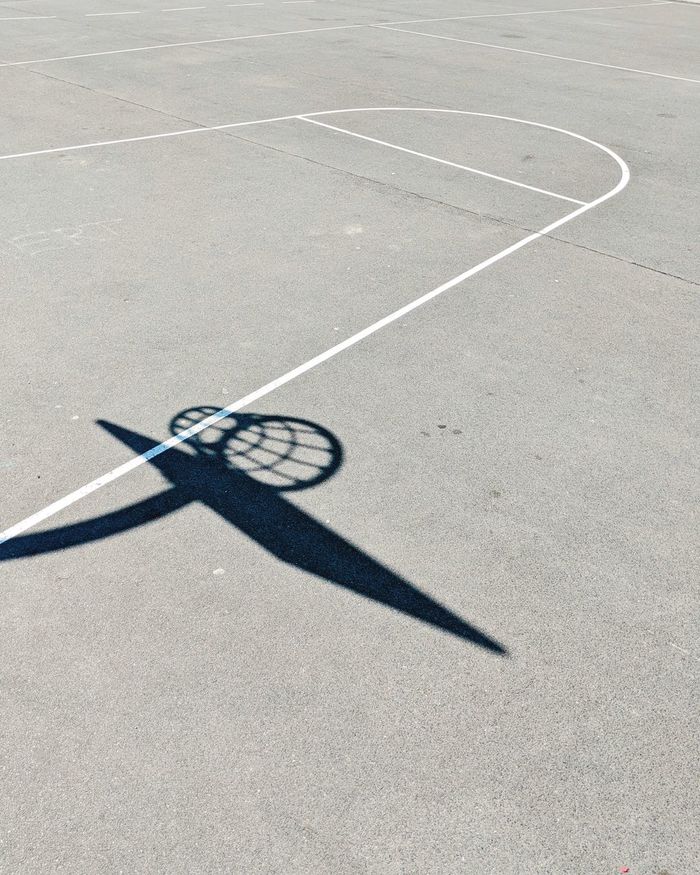 Shadow of basketball hoop on ground