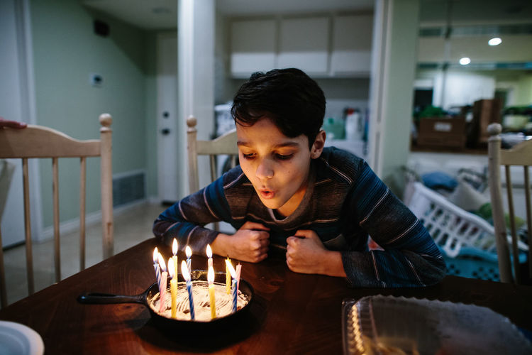 Boy blows out the candles on his cast iron pan birthday cake