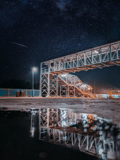 Reflective image of a crossover in railway station with the sky full of stars