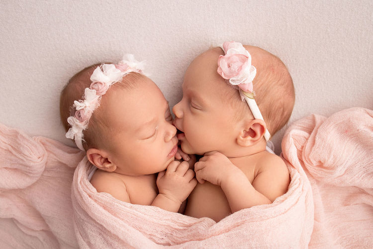 Close-up of twins sleeping on bed