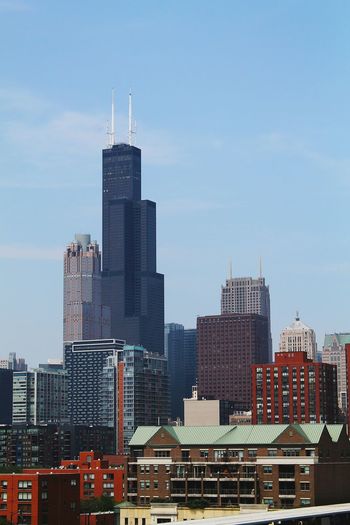 Willis tower amidst office buildings against sky