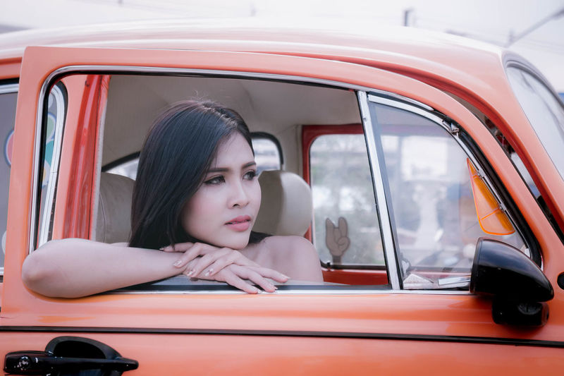 Close-up of woman looking through car window