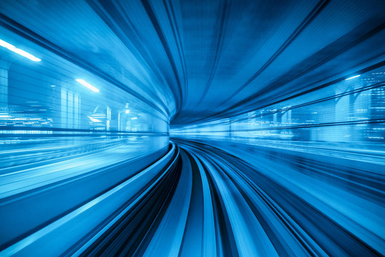 Blurred motion of illuminated blue tunnel