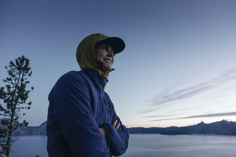 A woman smiles while enjoying crater lake national park in oregon.