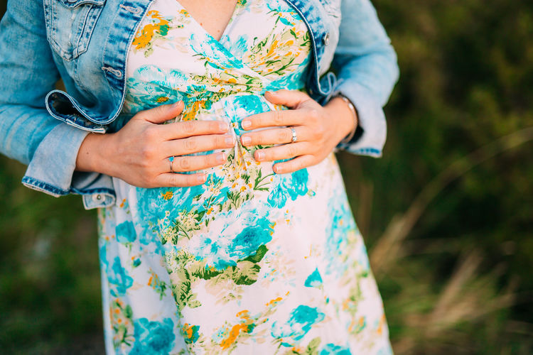 Midsection of pregnant woman standing outdoors