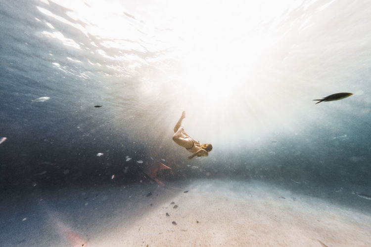 Underwater photography, woman swimming in the mediterranean sea.