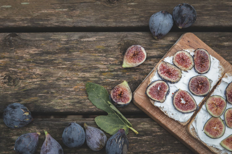 Cream cheese sandwich with figs served on wooden board with copy space