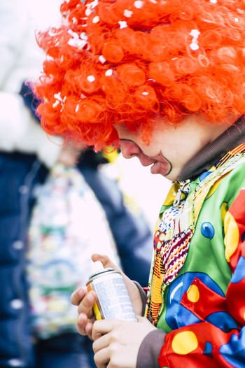 Side view of teenage boy wearing clown costume