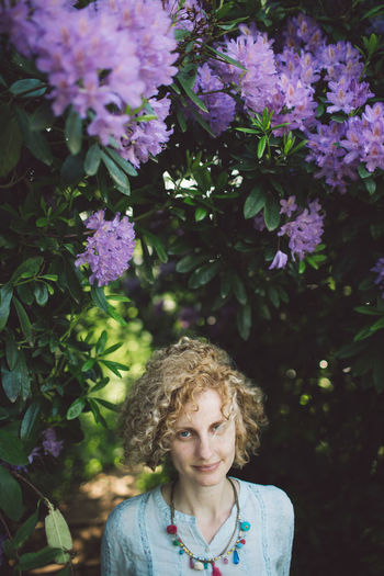 Portrait of woman against purple flowering plants