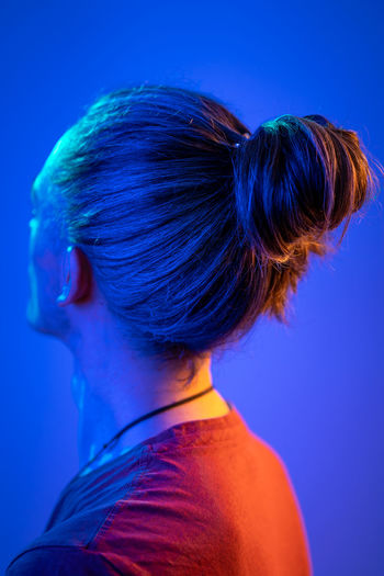 Rear view of woman against blue background