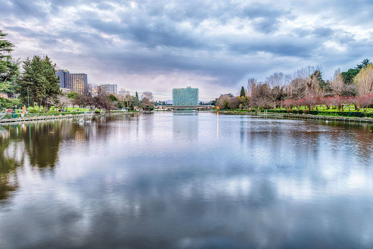 Scenic view of artificial lake in eur district against cloudy sky