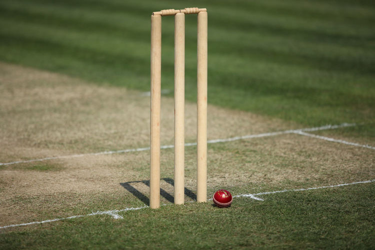 Close-up of ball next to cricket stumps 