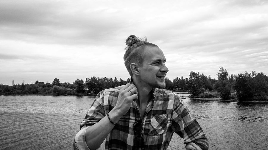 Man standing by lake against sky