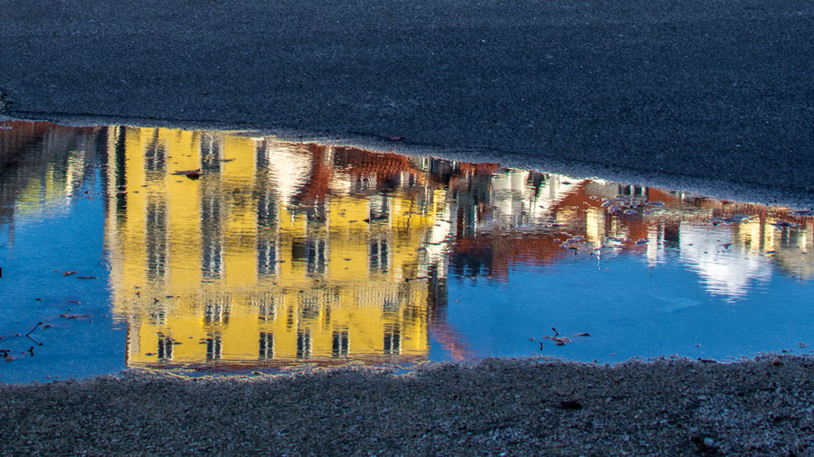 Reflection of building in puddle on road