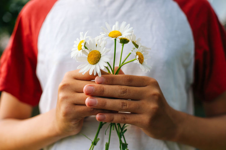 Holding a bouquet of daisies