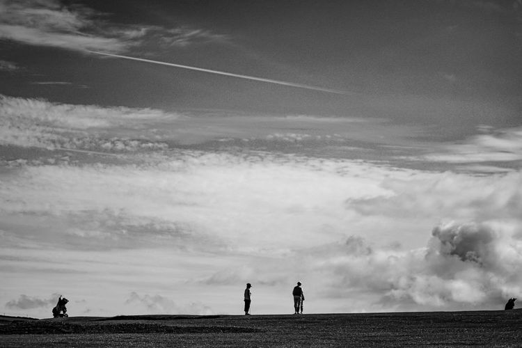Silhouette people standing on field against sky