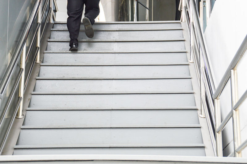 Low section of man walking on stairs