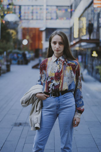 Portrait of young woman standing in city