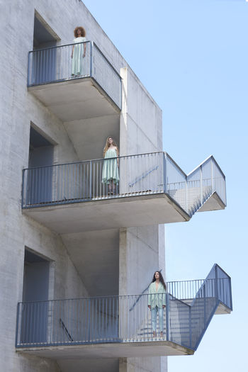 Low angle view of men standing on staircase against building