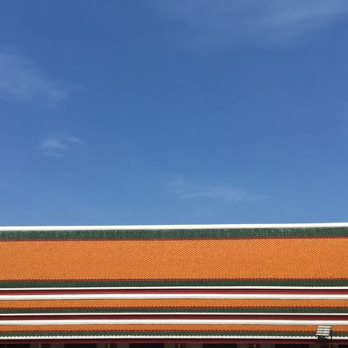 Low angle view of multi colored roof against sky