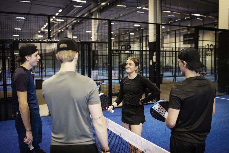 Group of friends talking at indoor padel court