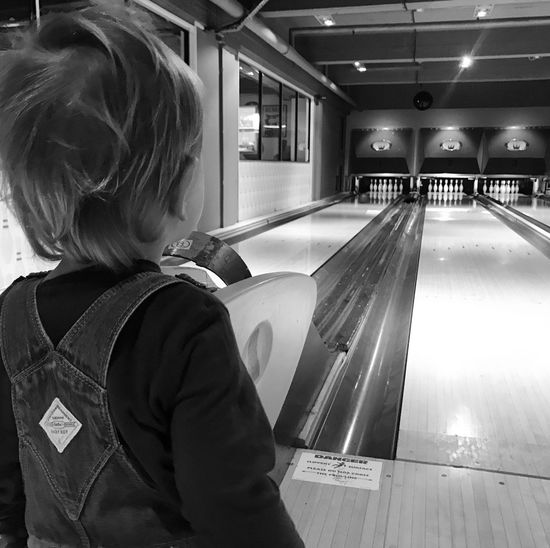 Rear view of boy looking at bowling alley