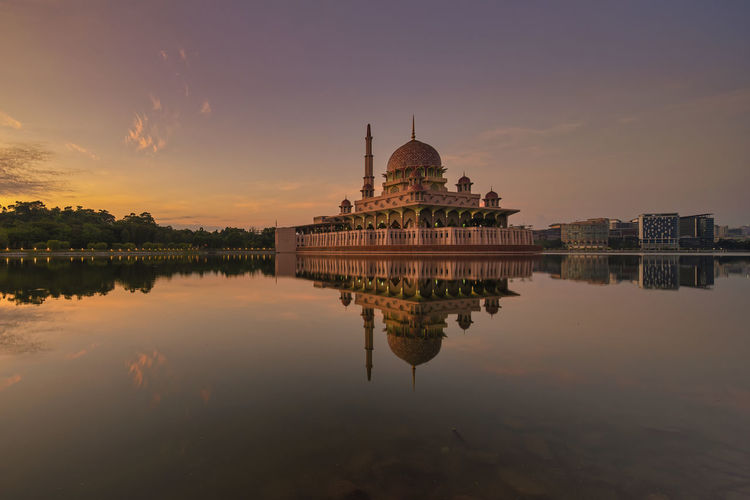 Reflection of temple in lake at sunset