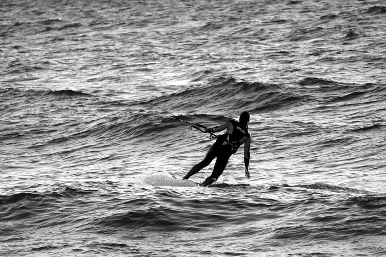 Rear view of man kiteboarding in sea
