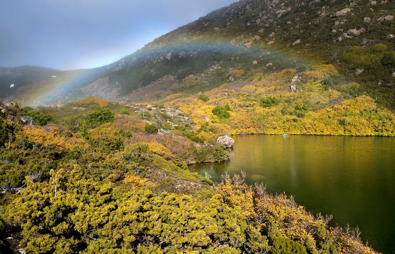 Scenic view of lake by mountain against sky