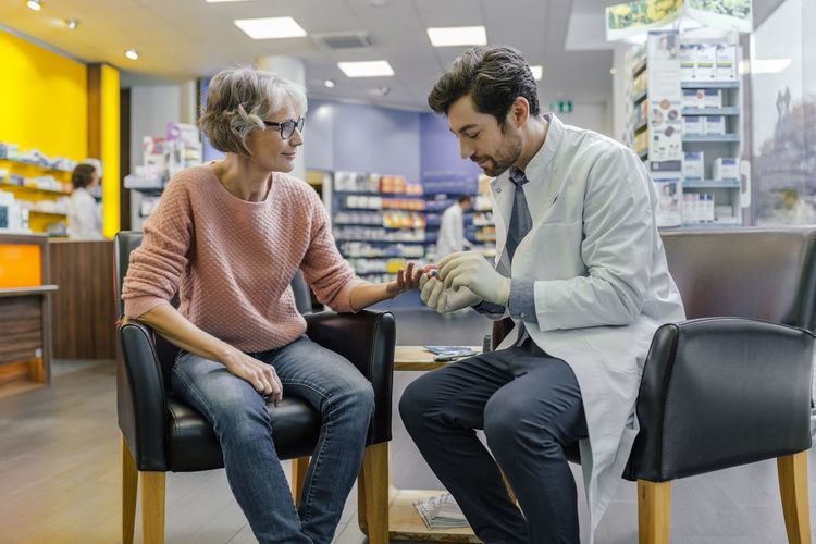 Pharmacist measuring blood sugar of customer in pharmacy