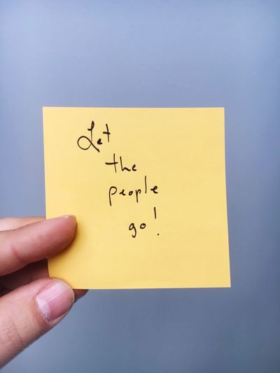 Cropped hand holding adhesive note
