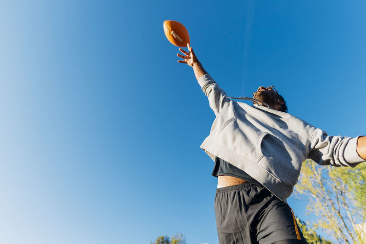 Sportsman throwing american football on sunny day