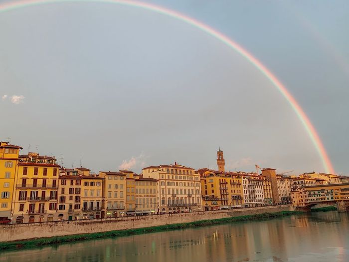 Rainbow over river with buildings in background