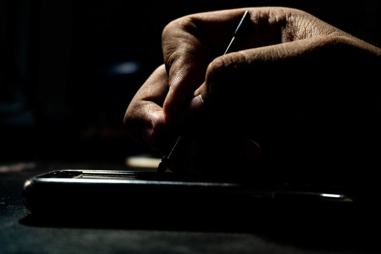 Cropped hand using smart phone with digitized pen