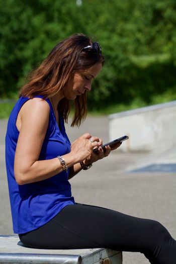 Midsection of woman using mobile phone outdoors