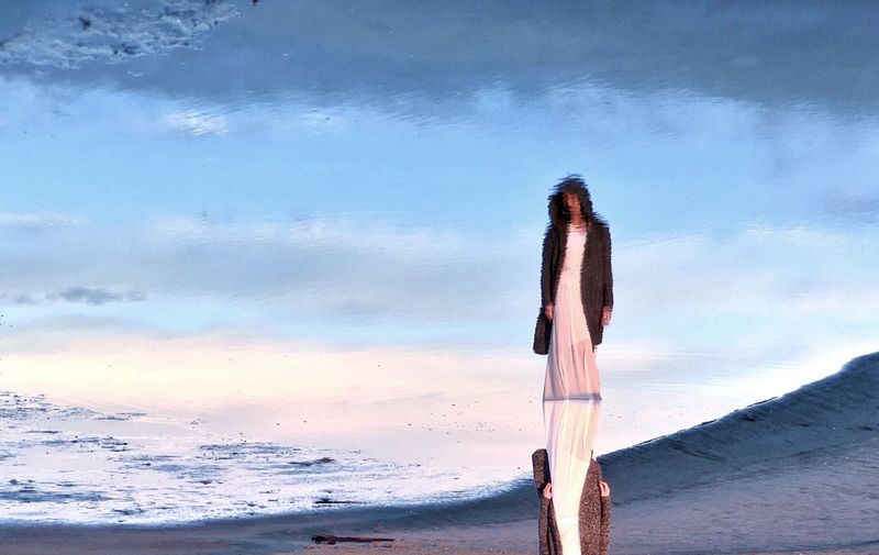 Upside down image of woman reflection at beach
