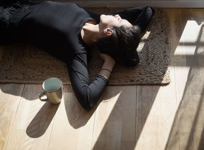 High angle view of woman lying on floor at home