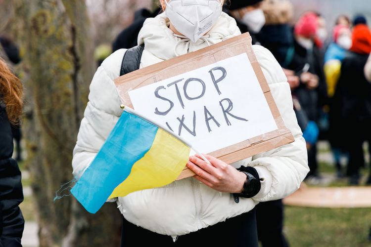 Stop war banner holding and ukraine flag at a demonstration in the city center in berlin