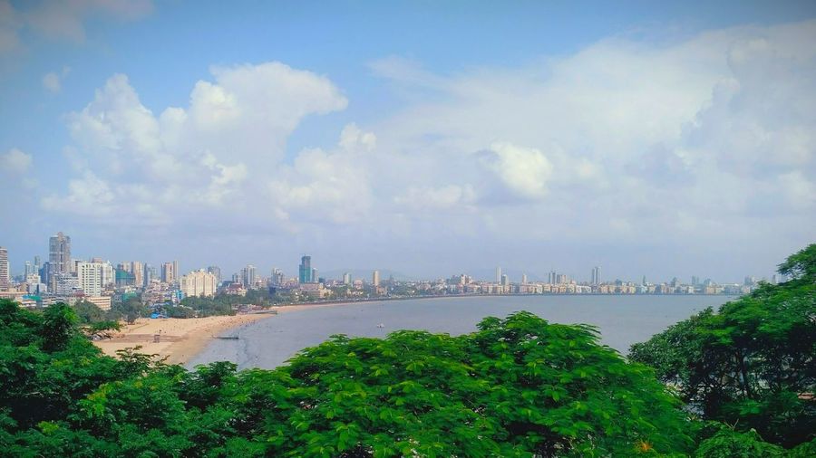 Panoramic view of buildings and trees against sky