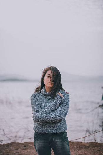 Young woman looking at sea against sky