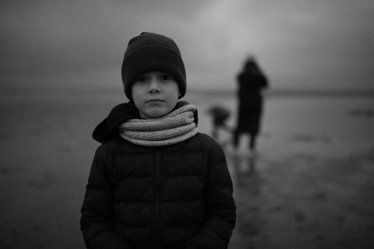 Full length of boy standing at beach during winter