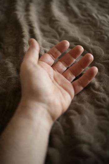 Low section of hand on bed