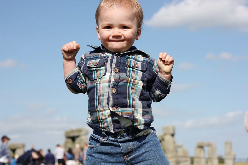 Portrait of baby boy at stonehenge against sky