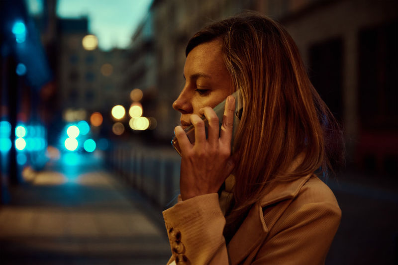 Woman use smartphone at night city street