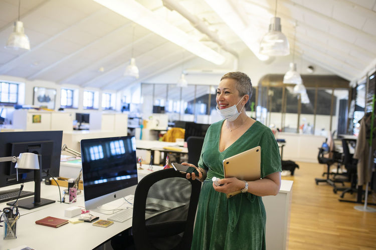 Smiling businesswoman standing in empty office