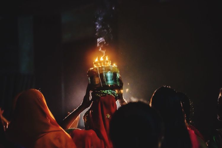 Rear view of women celebrating traditional festival at night